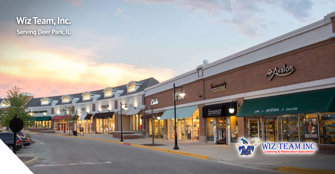 Deer Park Town Center storefronts at sunset, featuring shops like Francesca's, Aveda, and Avalon, with Wiz Team, Inc. branding, highlighting cleaning services in Deer Park, IL.