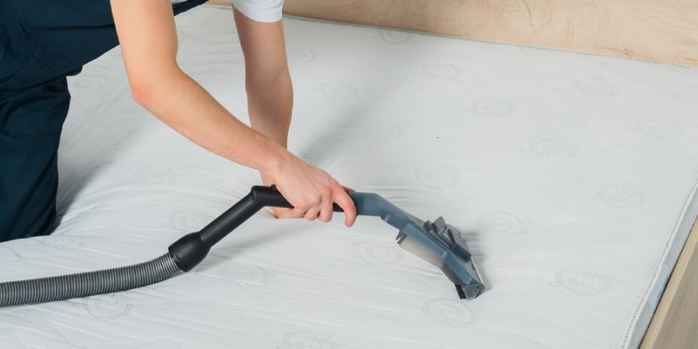 Professional cleaning of a mattress using a vacuum, emphasizing hygiene and allergen control for a healthier sleep environment.