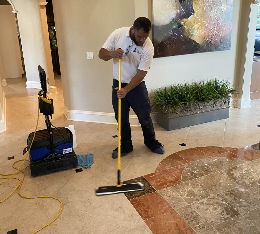 Professional cleaner using a mop on polished tile floor, showcasing efficient cleaning techniques in a residential space, emphasizing eco-friendly cleaning practices.