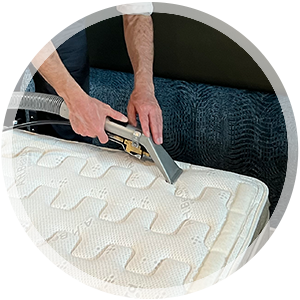 Professional mattress cleaning service in action, technician using equipment to deep clean mattress fabric for a healthier home environment.