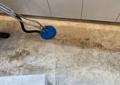 Professional tile and grout cleaning in progress, showcasing advanced steam cleaning equipment on stained tile surface.