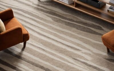 Carpet with a striped pattern in a living room setting, featuring two orange armchairs and a wooden shelf, illustrating the comfort and style of carpets emphasized in carpet cleaning and restoration services.