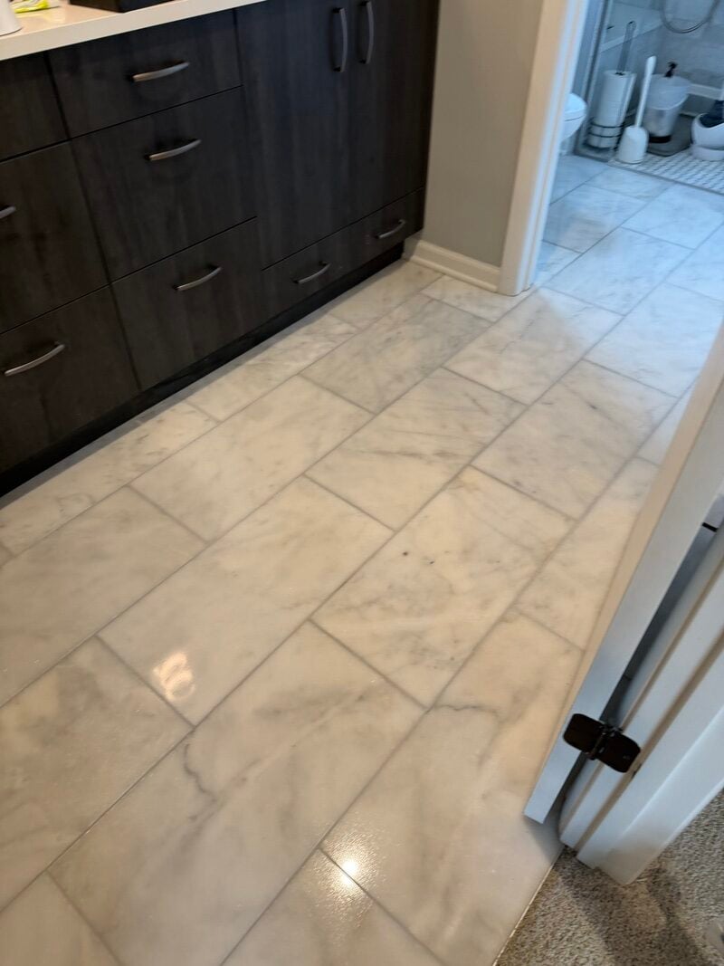 Restored glossy tile floor in a bathroom, showcasing the transformation from dull and uneven surfaces to a polished finish, highlighting professional tile and grout cleaning services in Northbrook, IL.